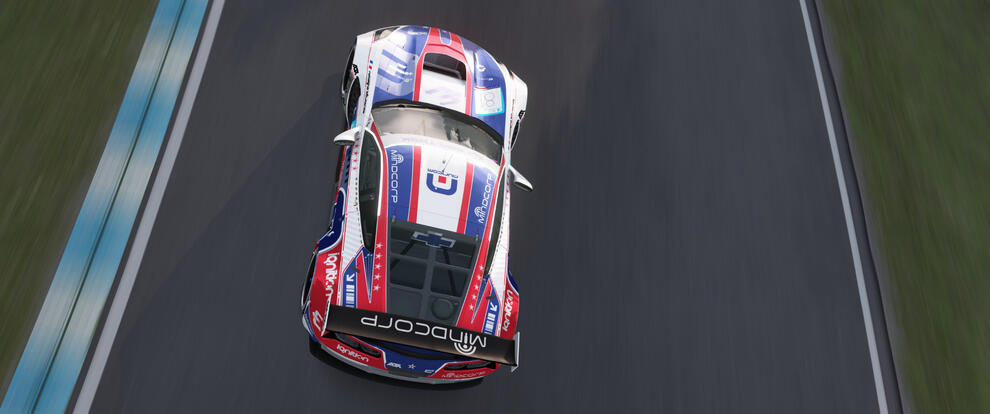 Picture of a Corvette C7.R sporting an Auricom livery inspired by the Auricom team from the Wipeout series. It is white, blue and red.